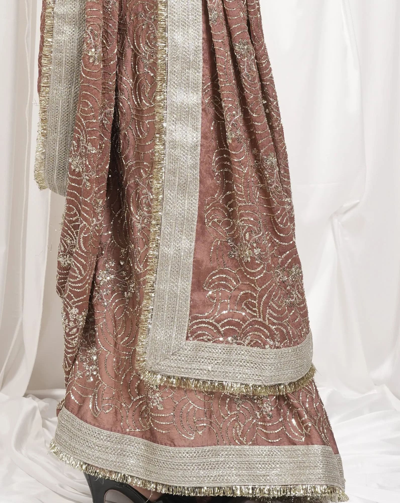 The gold zari border and sequin embroidery along the hem of a dusty-rose Sheshri Fashion lehenga